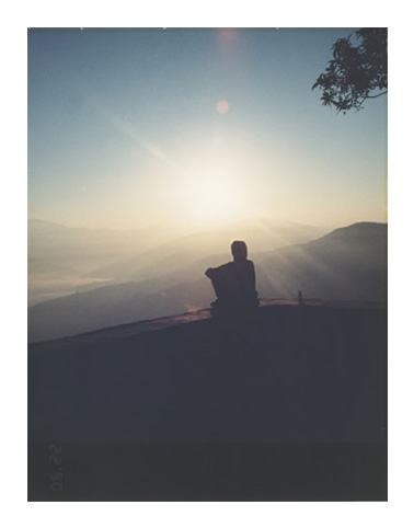 Shilouette of a woman watching a sunrise.